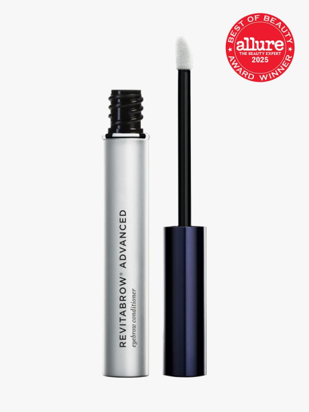 RevitaLash RevitaBrow in branded silver tube next to navy cap with doe foot applicator on light gray background with red Allure Best of Beauty seal in the top right corner